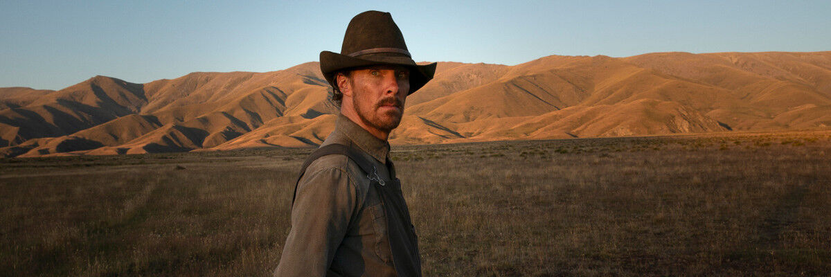 Aktor Benedict Cumberbatch w kapeluszu na prerii, w tle wzgórza 