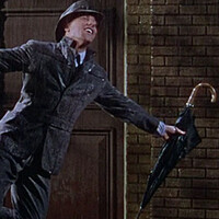 Mężczyzna tańczący na deszczu, kręcący się na lampie ulicznej z parasolem w ręce 