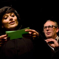 Fotografia ze spektaklu. Agata ochota czyta tekst z kartki Antoniemu Rotowi