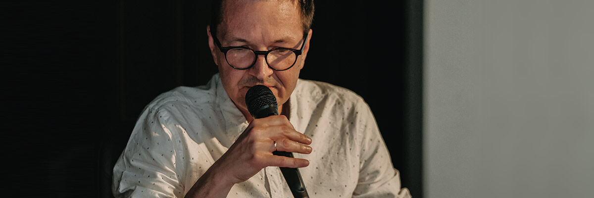 Pisarz Rafał Księżyk trzymający mikrofon
