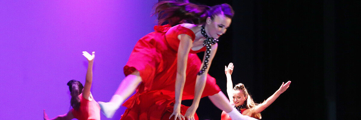Tancerki w czerwonych sukienkach na scenie podczas występu