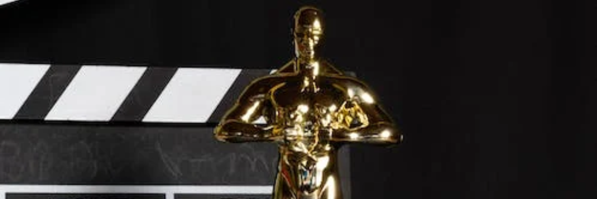 Złota statuetka Oscara, a za nią klaps filmowy