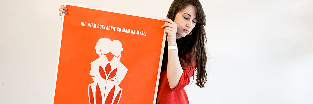 Projektanka Joanna Ambroz trzymająca swój plakat