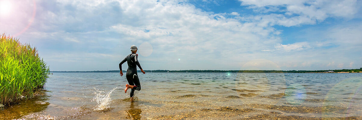 Kobieta biegnąca po wodzie w stroju triathlonowym