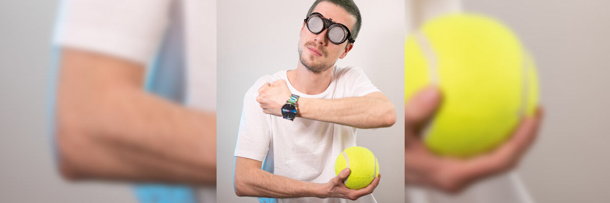 Raper Mikser w dziwnych okularach trzymający w dłoni piłeczkę do tenisa.